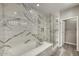 Elegant bathroom with marble-style walls, shower with glass door, soaking tub, and tile floors at 815 E Rose Ln # 105, Phoenix, AZ 85014