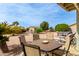 Outdoor patio with dining table, chairs, desert landscaping, and blue sky create perfect outdoor retreat at 8229 E Farmdale Dr, Mesa, AZ 85208