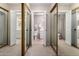 Bright bathroom featuring a white vanity, tile floor, open closet with mirrored doors, and ample natural light at 8229 E Farmdale Dr, Mesa, AZ 85208