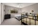 Neutral bedroom showcasing two beds, a ceiling fan, large window, and a dark dresser at 8229 E Farmdale Dr, Mesa, AZ 85208