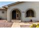 Welcoming front exterior featuring arched entryway, desert landscaping, and charming details at 8229 E Farmdale Dr, Mesa, AZ 85208