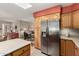 Spacious kitchen with stainless steel refrigerator and light wood cabinetry at 8229 E Farmdale Dr, Mesa, AZ 85208