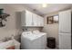 Functional laundry room equipped with modern appliances, storage cabinets, and a practical utility sink at 8229 E Farmdale Dr, Mesa, AZ 85208