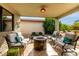 Inviting covered patio with comfortable seating around a stone fire pit, perfect for outdoor relaxation at 8229 E Farmdale Dr, Mesa, AZ 85208