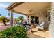 Inviting covered patio with seating around a stone fire pit and desert landscaping at 8229 E Farmdale Dr, Mesa, AZ 85208