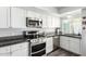 Updated kitchen featuring white cabinetry, granite countertops and stainless appliances with natural light at 860 N Mcqueen Rd # 1213, Chandler, AZ 85225
