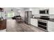 Bright kitchen features stainless appliances, granite countertops, wood-look tile flooring, and dining area at 860 N Mcqueen Rd # 1213, Chandler, AZ 85225