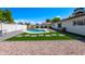 Inviting backyard features a sparkling pool, patio area, green grass, and a gravel bed at 8602 E Whitton Ave, Scottsdale, AZ 85251