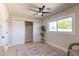 Bedroom with ceiling fan, decorative plant, a window, and closet with white sliding doors at 8602 E Whitton Ave, Scottsdale, AZ 85251