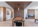 Elegant dining area with a long wooden table, modern ceiling design, and view into the living space at 8602 E Whitton Ave, Scottsdale, AZ 85251