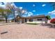 Lovely home with well-maintained landscaping, desert rock, and mature trees against a beautiful blue sky at 8602 E Whitton Ave, Scottsdale, AZ 85251