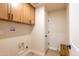 Functional laundry room with overhead cabinets, hook for a hanging a garment, and space for machines at 8602 E Whitton Ave, Scottsdale, AZ 85251