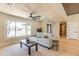 Bright living room featuring a neutral sofa, coffee table, large window, and unique ceiling fan at 8602 E Whitton Ave, Scottsdale, AZ 85251