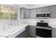 Updated kitchen features gray cabinets, modern stainless steel appliances, farmhouse sink and white subway tile backsplash at 8841 S 51St St # 1, Phoenix, AZ 85044