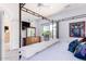 Main bedroom boasts a canopy bed, balcony access, and a dresser with wall-mounted TV at 8841 S 51St St # 1, Phoenix, AZ 85044