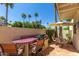Outdoor kitchen with a built-in gas grill, bar seating, tiled patio, desert landscaping, and palm trees at 8841 S 51St St # 1, Phoenix, AZ 85044