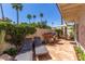 Relaxing patio area featuring lounge chairs, a built-in grill, desert landscaping, and palm trees at 8841 S 51St St # 1, Phoenix, AZ 85044