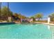 Community pool area with lounge chairs, lush greenery, and mountain views in the distance at 8841 S 51St St # 1, Phoenix, AZ 85044
