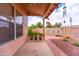 Charming backyard with a covered patio, brick accents, and desert landscaping at 910 W Redondo Dr, Gilbert, AZ 85233