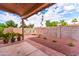 Charming backyard with a covered patio, brick accents, and desert landscaping at 910 W Redondo Dr, Gilbert, AZ 85233