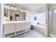 Bright bathroom with double sinks, a tub, a shower, and a large mirror with vanity lights at 910 W Redondo Dr, Gilbert, AZ 85233
