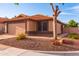 Beige home with a 2-car garage, driveway, and desert landscaping at 910 W Redondo Dr, Gilbert, AZ 85233