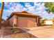 Beige home with a 2-car garage, driveway, and desert landscaping at 910 W Redondo Dr, Gilbert, AZ 85233