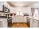Bright eat-in kitchen featuring white cabinets, stainless appliances, and an arched window at 910 W Redondo Dr, Gilbert, AZ 85233