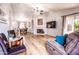 Cozy living room featuring a fireplace, TV, and views to the dining area at 910 W Redondo Dr, Gilbert, AZ 85233