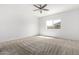 A bright bedroom features neutral carpet, a ceiling fan, and a window at 947 E Wiley Way, Casa Grande, AZ 85122