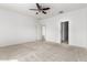 A bright bedroom features neutral carpet, a ceiling fan, a door to a walk-in closet, and another door at 947 E Wiley Way, Casa Grande, AZ 85122