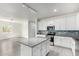 Bright kitchen features white cabinetry, gray granite countertops, stainless steel appliances, and a kitchen island at 947 E Wiley Way, Casa Grande, AZ 85122