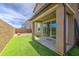 Outdoor patio area with views of the artificial grass backyard, a covered patio, and block fencing at 9923 E Tahoe Ave, Mesa, AZ 85212
