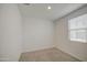 A bedroom featuring neutral carpet, fresh paint, a ceiling light, and natural light from a window at 9923 E Tahoe Ave, Mesa, AZ 85212