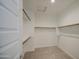 A large walk in closet with built in shelving with white walls and carpeted floor at 9923 E Tahoe Ave, Mesa, AZ 85212