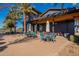 Outdoor patio area with comfortable seating at the community clubhouse, surrounded by palm trees at 9923 E Tahoe Ave, Mesa, AZ 85212