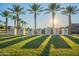 Scenic Cadence community entrance with manicured lawn, stone signage, and swaying palm trees bathed in sunlight at 9923 E Tahoe Ave, Mesa, AZ 85212