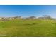 Expansive grassy area in community park with palm trees and seating for relaxation and recreation at 9923 E Tahoe Ave, Mesa, AZ 85212