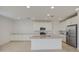 Modern kitchen with stainless steel appliances, island with sink, and white cabinets at 9923 E Tahoe Ave, Mesa, AZ 85212