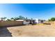 View of backyard with low brick wall and white brick outbuilding under clear blue sky at 1038 E Northern Ave, Phoenix, AZ 85020