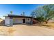 Single-story home featuring a covered carport, red front door, and desert landscaping at 1038 E Northern Ave, Phoenix, AZ 85020