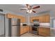 Well-lit kitchen with stainless steel appliances, wood cabinets, ceiling fan, and tile floor at 1038 E Northern Ave, Phoenix, AZ 85020