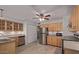 Charming kitchen features stainless steel appliances, wooden cabinets, tile backsplash, and ceiling fan at 1038 E Northern Ave, Phoenix, AZ 85020