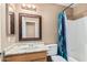 Bathroom featuring a sink with a mirror, a toilet and a shower with a blue curtain at 11321 W Austin Thomas Dr, Surprise, AZ 85378