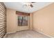 Cozy bedroom with natural light, ceiling fan, and faux log accent wall at 11321 W Austin Thomas Dr, Surprise, AZ 85378