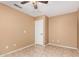 Neutral bedroom featuring a ceiling fan, a door, and neutral colored tile flooring at 11321 W Austin Thomas Dr, Surprise, AZ 85378