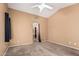 Cozy bedroom with neutral carpet and paint, ceiling fan, and doorway to bathroom and closet at 11321 W Austin Thomas Dr, Surprise, AZ 85378