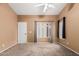 Bedroom with neutral carpet and paint, ceiling fan, large window, and closet space at 11321 W Austin Thomas Dr, Surprise, AZ 85378
