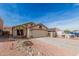Beige single-story home features desert landscaping, concrete driveway, and two-car garage at 11321 W Austin Thomas Dr, Surprise, AZ 85378