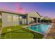 Backyard oasis featuring a pristine pool, putting green, and covered patio ideal for outdoor entertaining and relaxation at 11656 N San Clemente St, Surprise, AZ 85388
